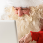 Weihnachtsmann am Laptop der grade etwas auf Social Media postet.